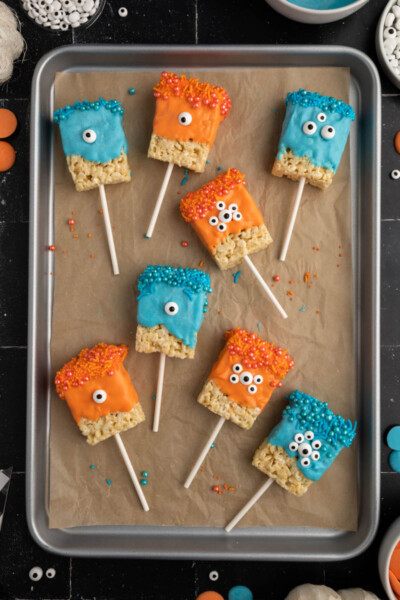 decorated monster rice krispie treats on a baking sheet lined with parchment paper
