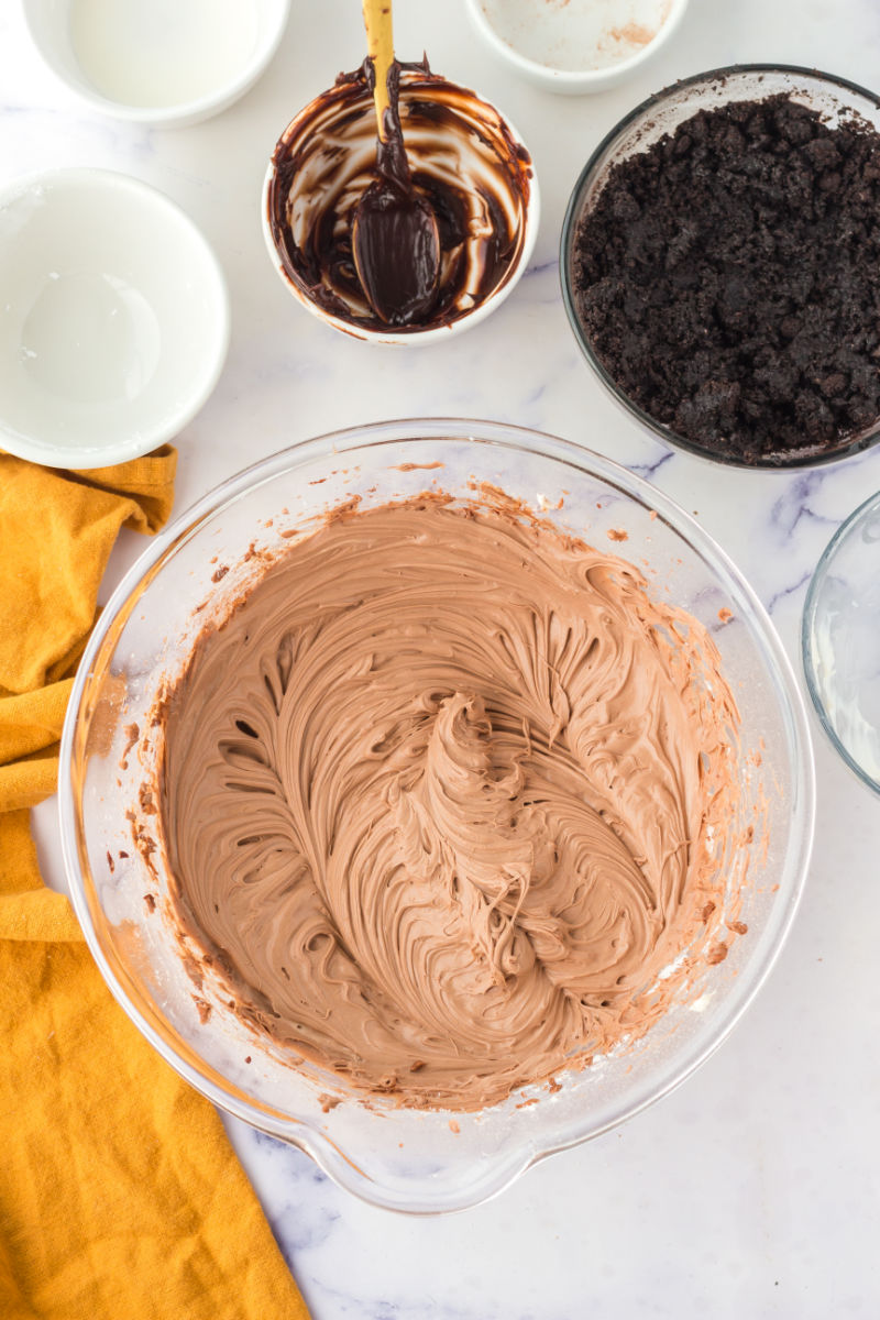 cream cheese, heavy cream, and hot fudge mixed together until smooth in a glass bowl