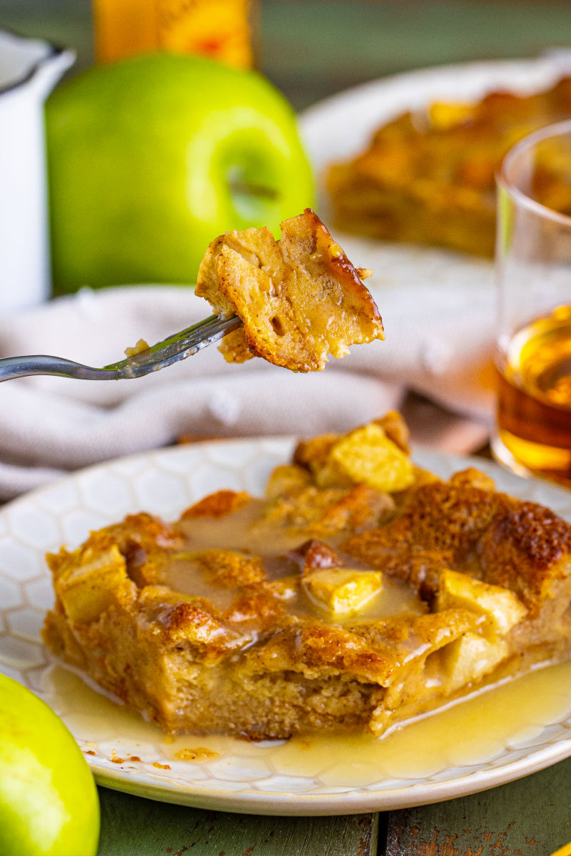 bite of fireball apple bread pudding on a fork over the plate