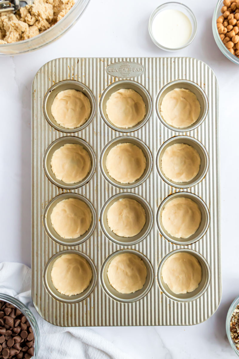 sugar cookie dough pressed into muffin tin cups