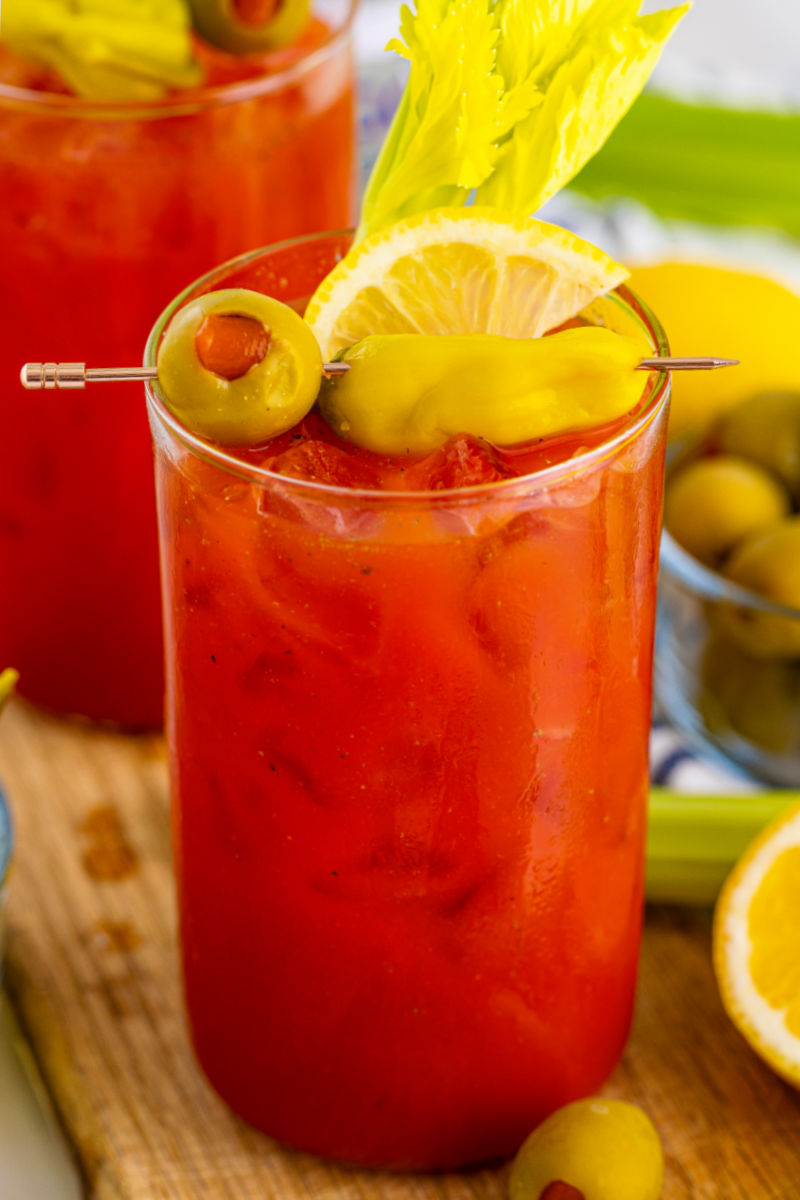 close up of a bloody mary cocktail with garnishes on a cocktail pick