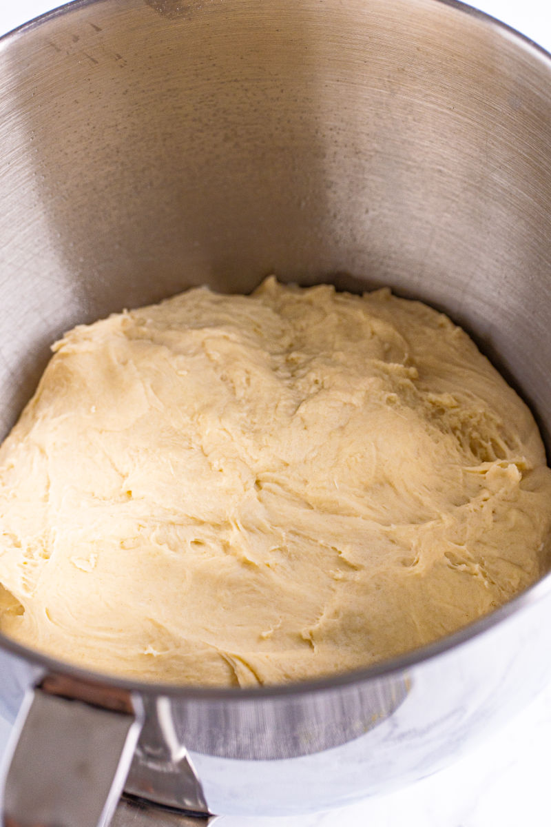 white bread dough in a stand mixer bowl after mixing