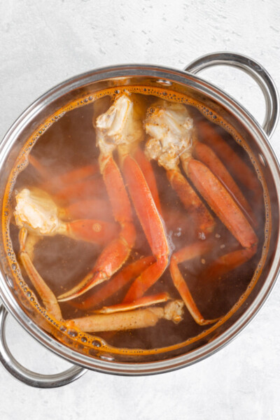 snow crab legs in a pot of hot seasoned water
