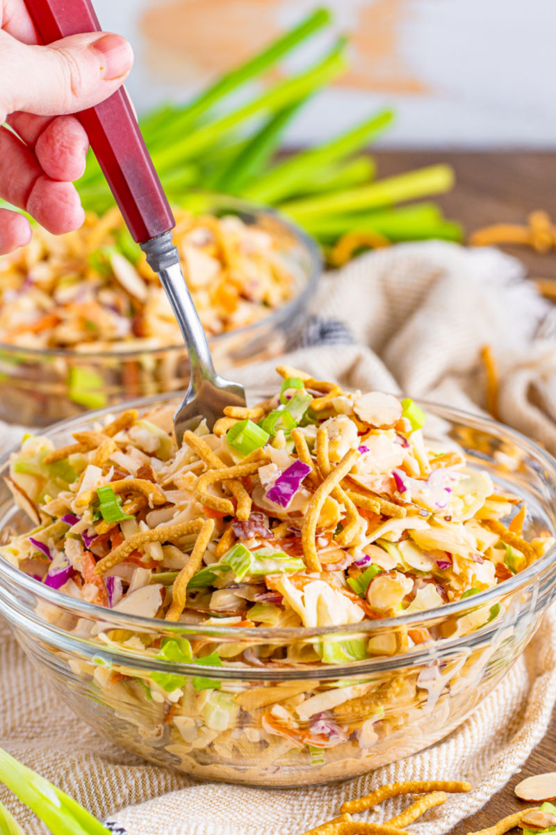 fork digging into a bowl of creamy asian slaw