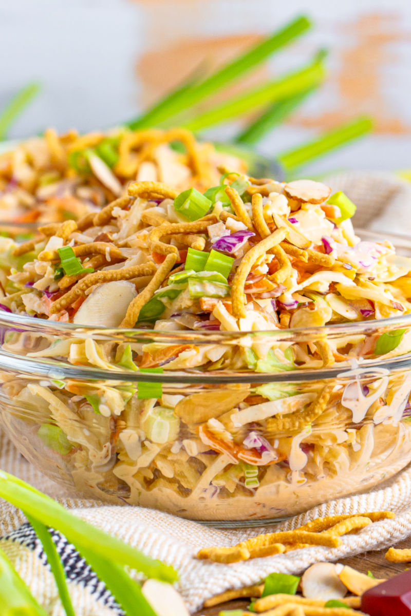 side view of a bowl of creamy asian slaw in a glass bowl