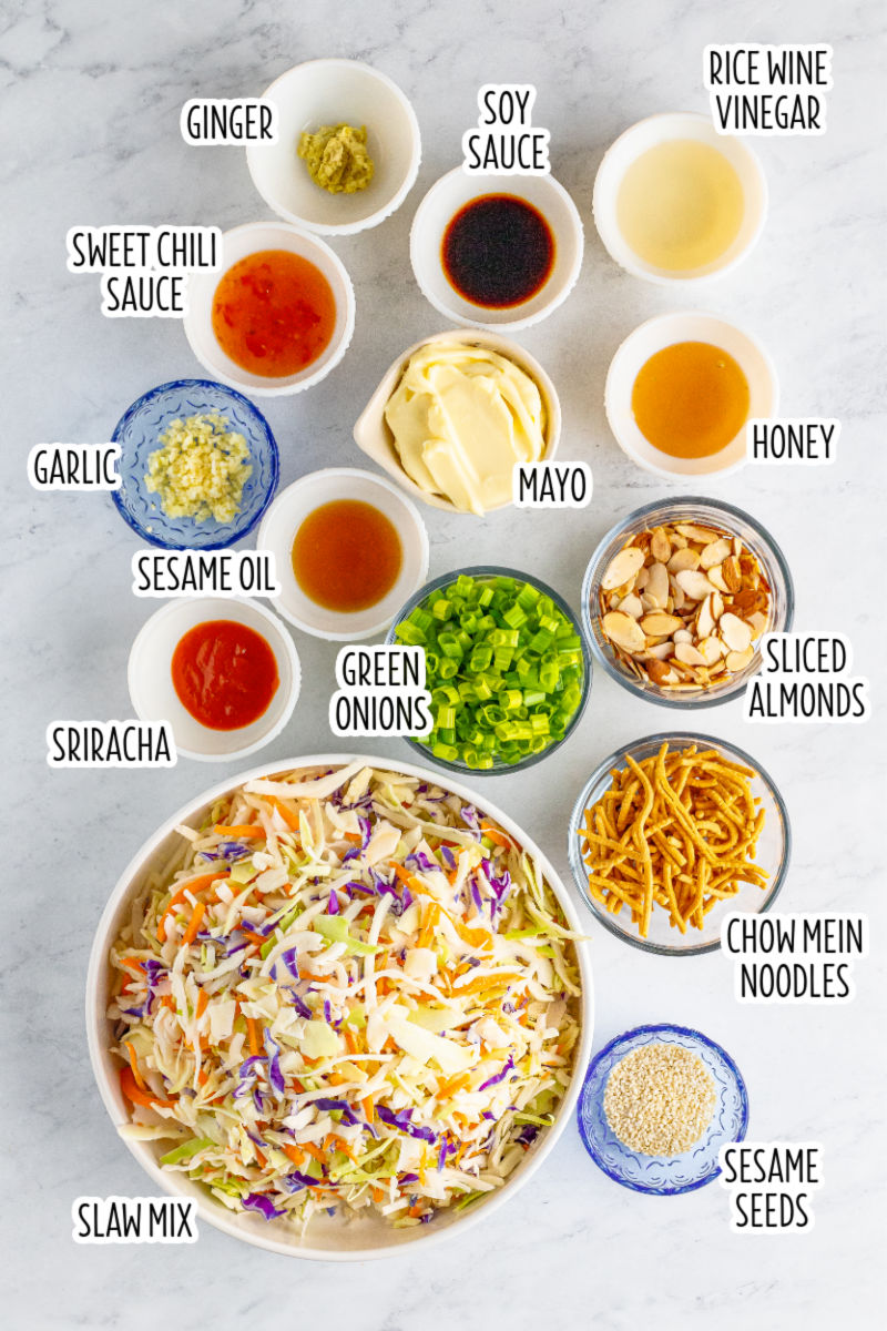 creamy asian slaw ingredients in bowls on a counter with text labels