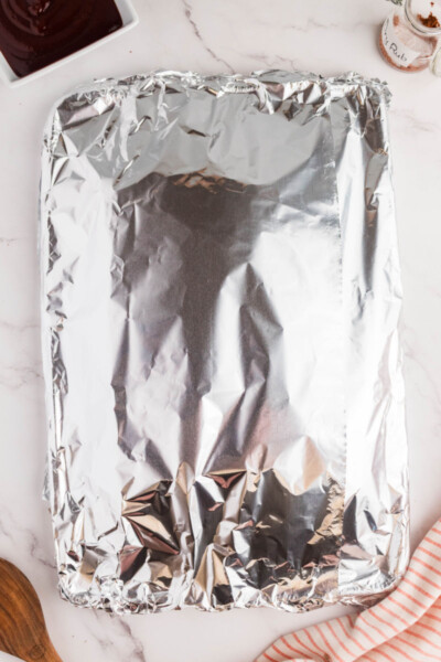 foil covered backing sheet with dry rub ribs on a wire rack