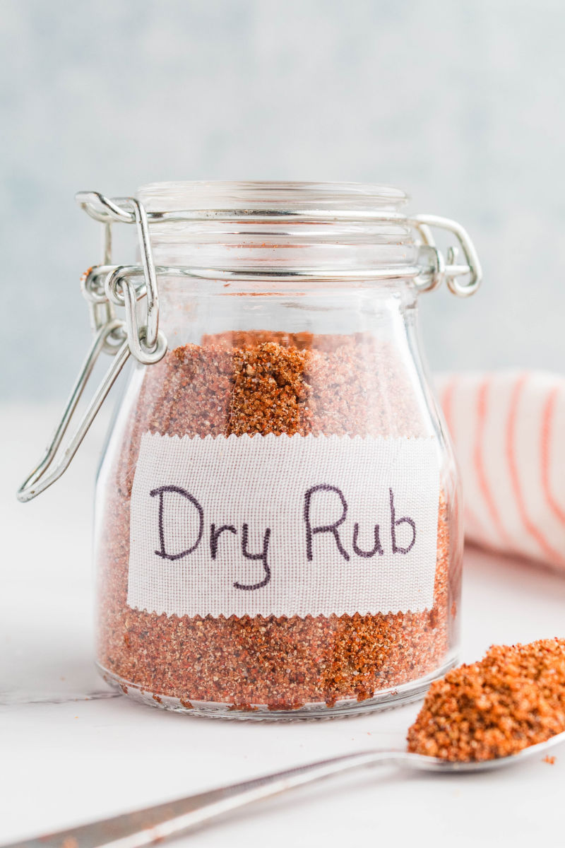 jar of rib rub with a sticker label and a spoon of rub next to the jar