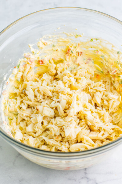 lump crab meat added to dip base in a glass mixing bowl