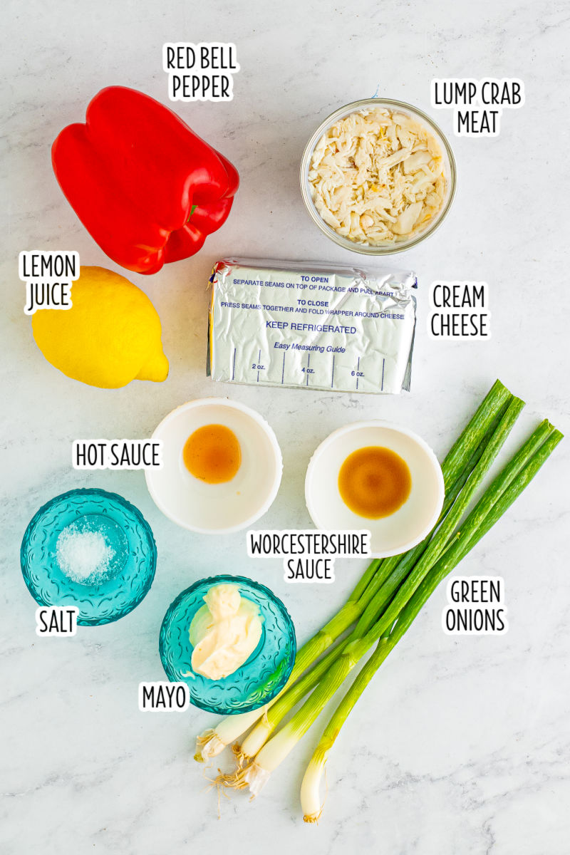 ingredients to make chilled crab dip laid out on a counter with text labels