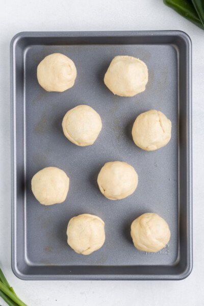 jalapeno popper bites rolled up an placed on a greased baking sheet before cooking