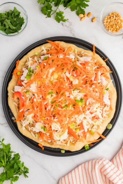 shredded mozzarella, chopped chicken, and veggies spread over peanut sauce a on a pizza crust