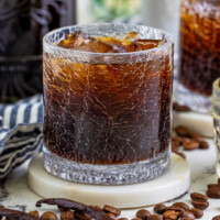 square image of homemade coffee liqueur over ice in a rocks glass